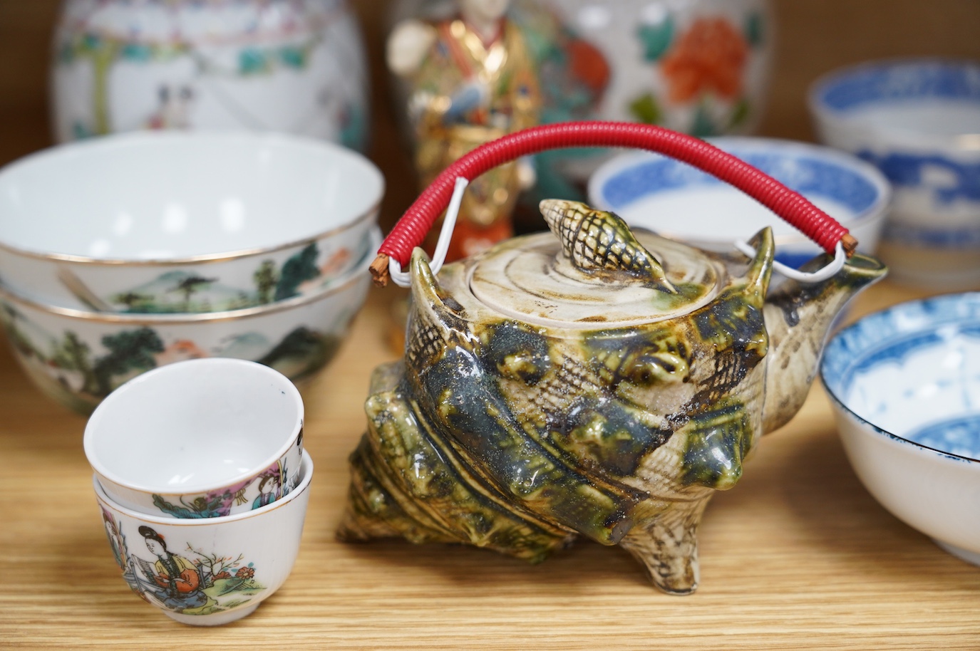 A collection of Chinese and Japanese ceramics to include tea bowls, a blue and white mug and teapot in the form of a shell, largest 13cm high. Condition - mostly good